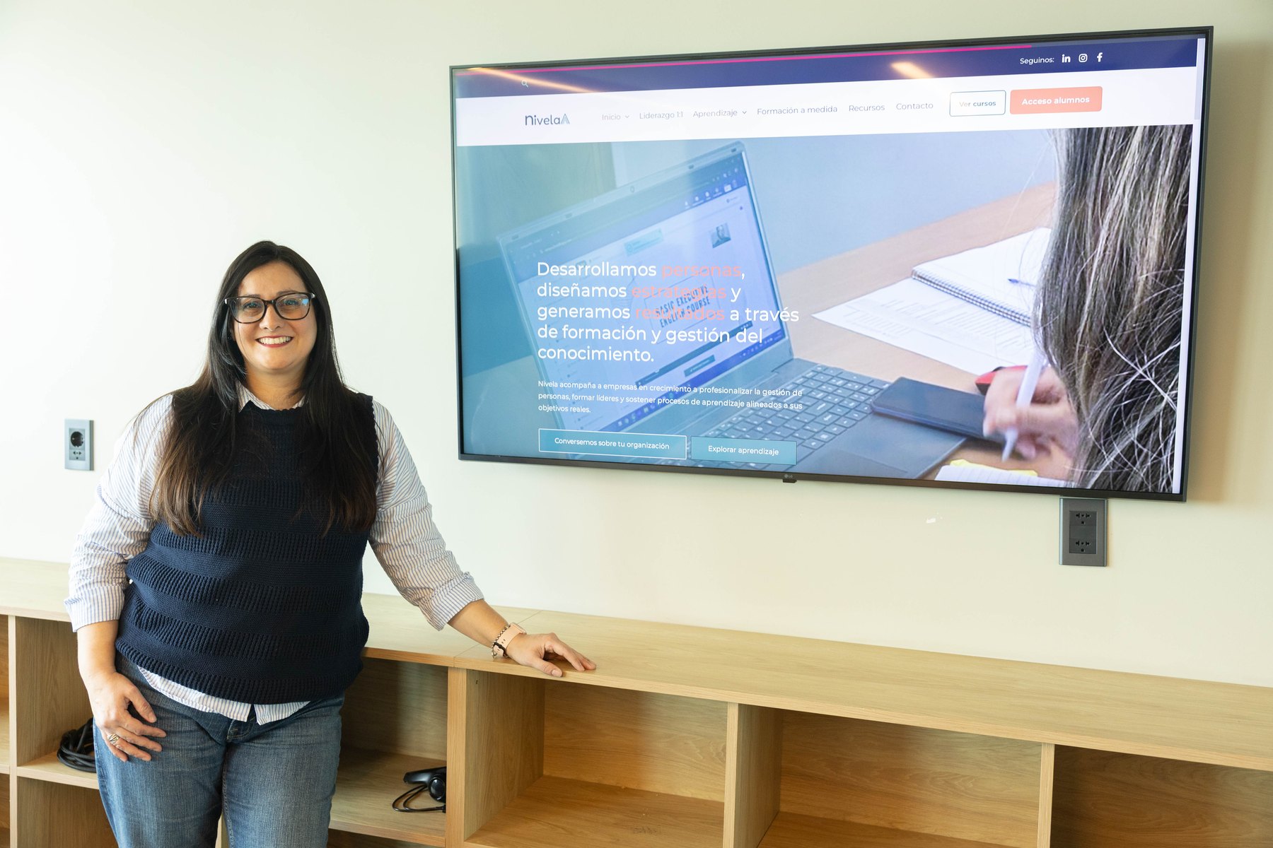 Laura Figueras, directora de Nivela Consultora, junto a la web de Nivela